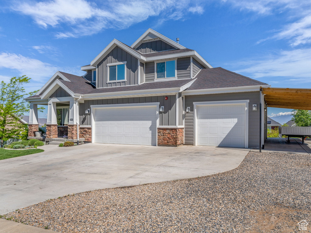 View of front of house featuring board and batten siding, concrete driveway, a garage, and roof with shingles