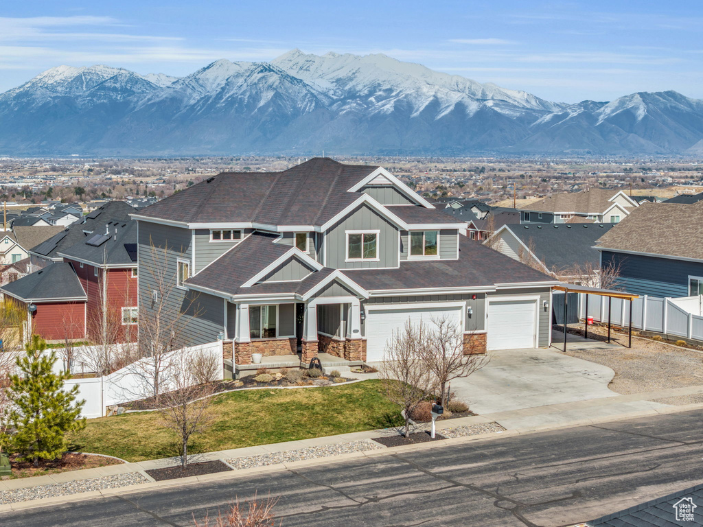 View of front of property featuring a mountain view, a residential view, board and batten siding, and fence