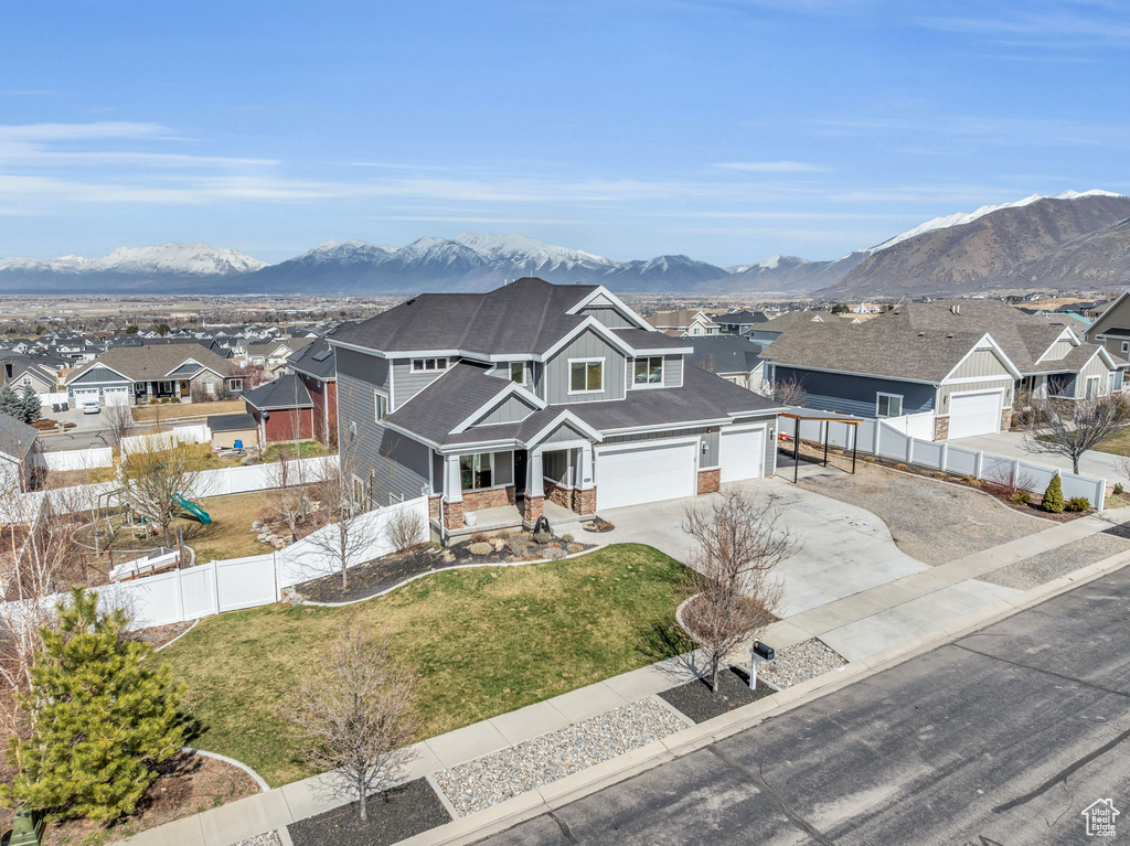 View of front of home with fence, a residential view, board and batten siding, concrete driveway, and a front yard