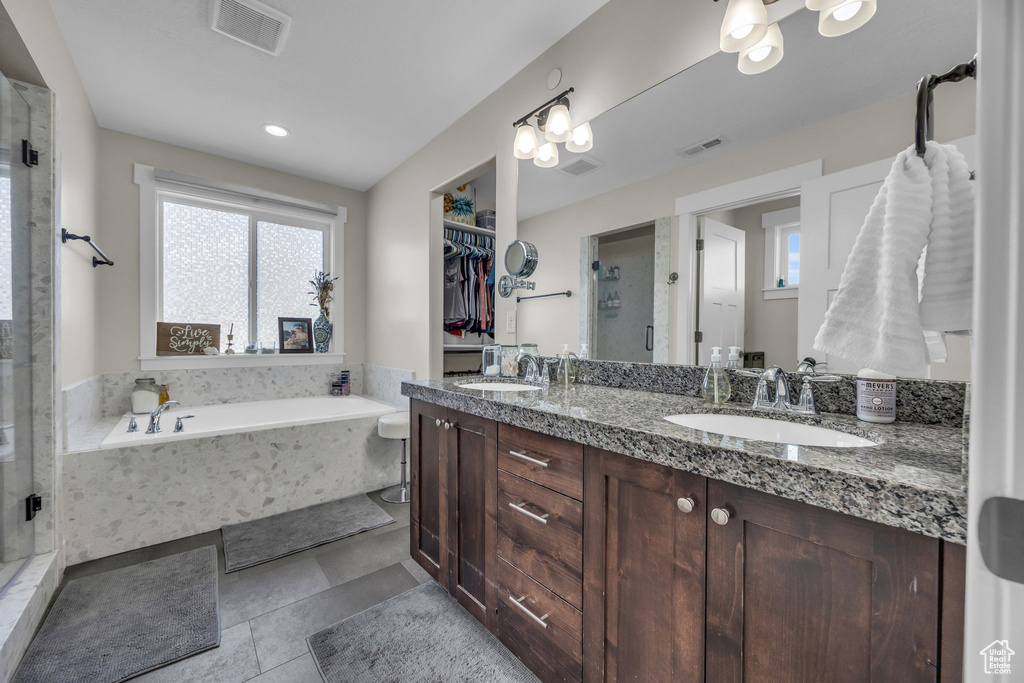 Bathroom featuring visible vents, a shower stall, a healthy amount of sunlight, and a sink