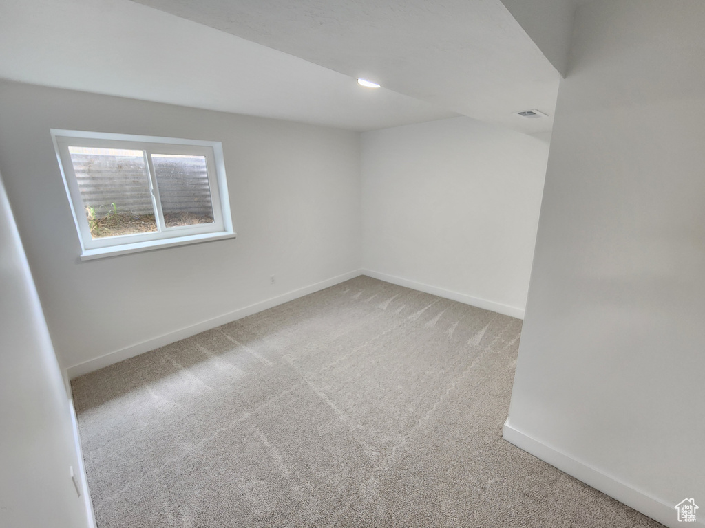 Empty room featuring visible vents, baseboards, and light colored carpet