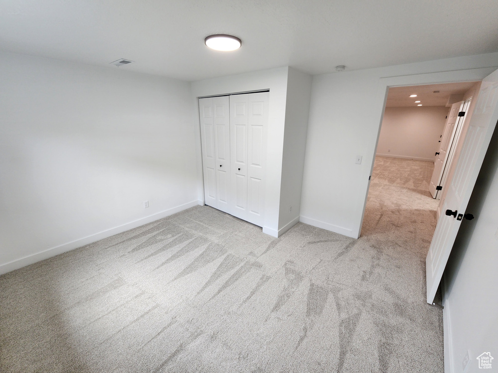 Unfurnished bedroom with visible vents, baseboards, a closet, and carpet flooring