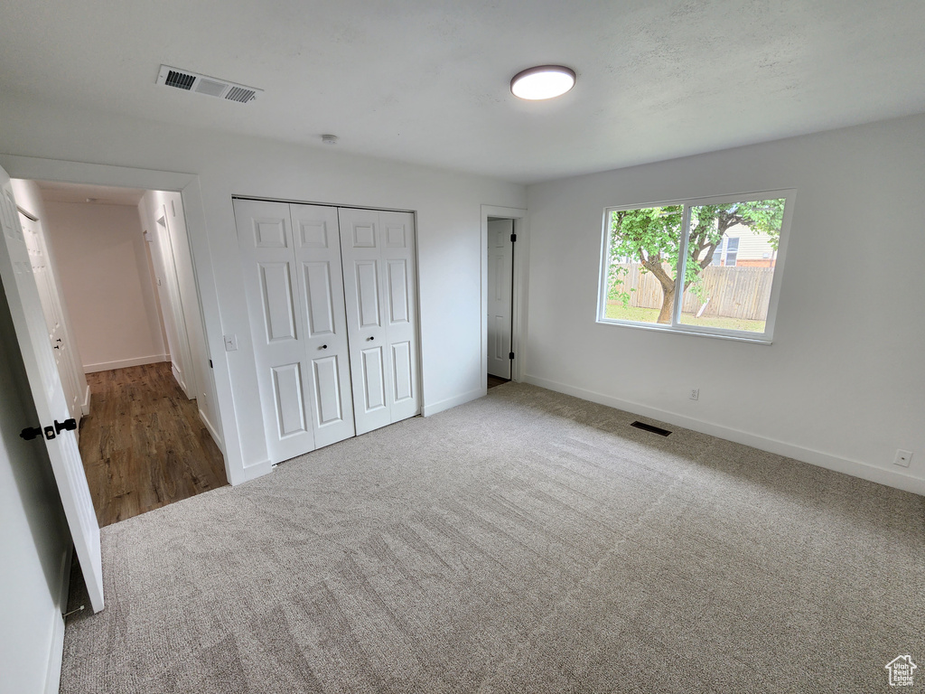 Unfurnished bedroom featuring a closet, visible vents, carpet flooring, and baseboards