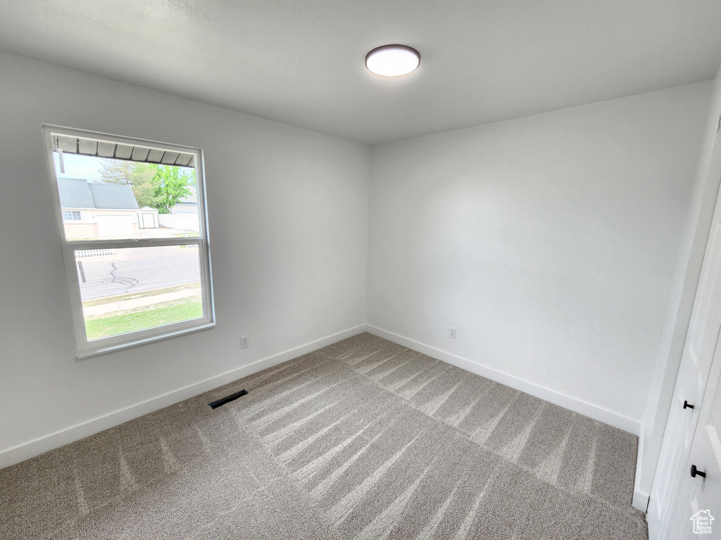 Carpeted empty room featuring baseboards