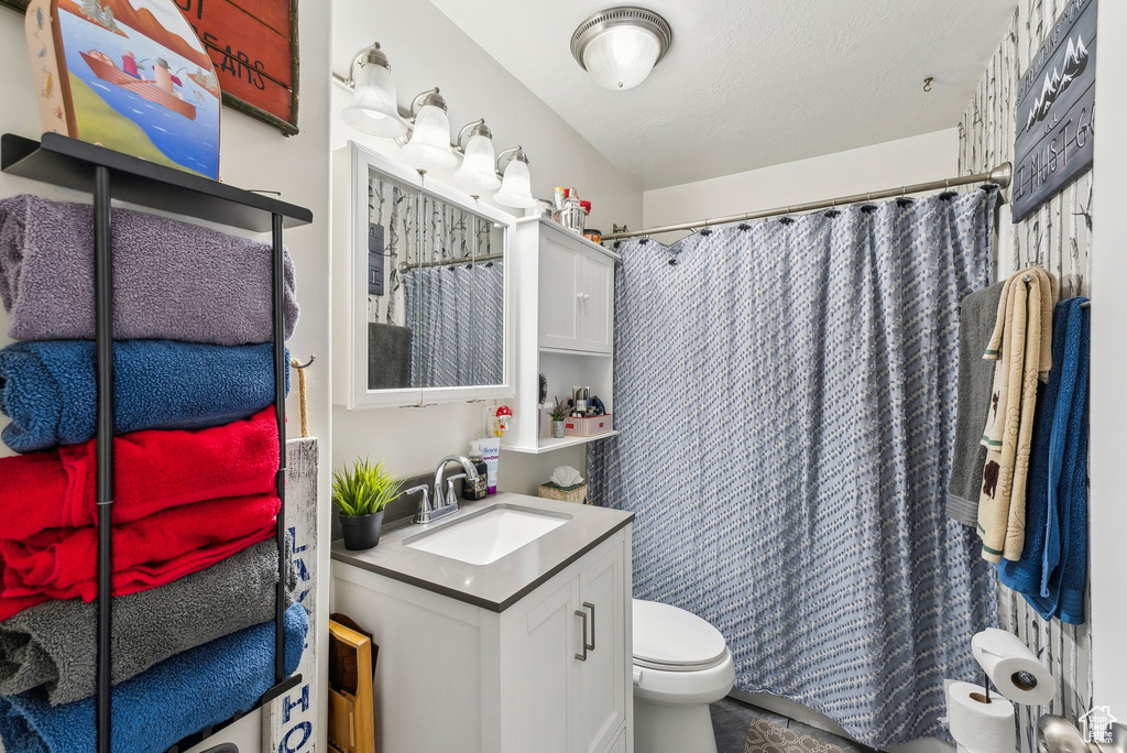 Full bath featuring vanity, curtained shower, and toilet