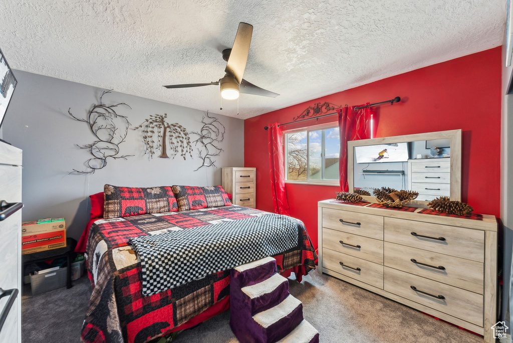 Carpeted bedroom with a textured ceiling and a ceiling fan