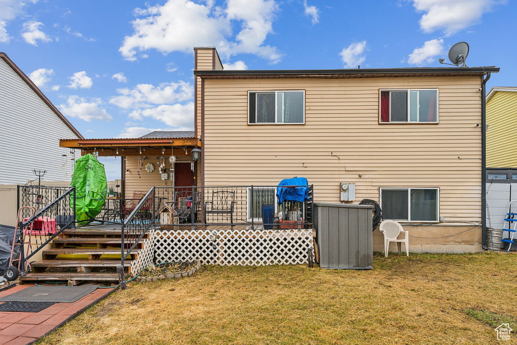 Back of property with a lawn and a deck