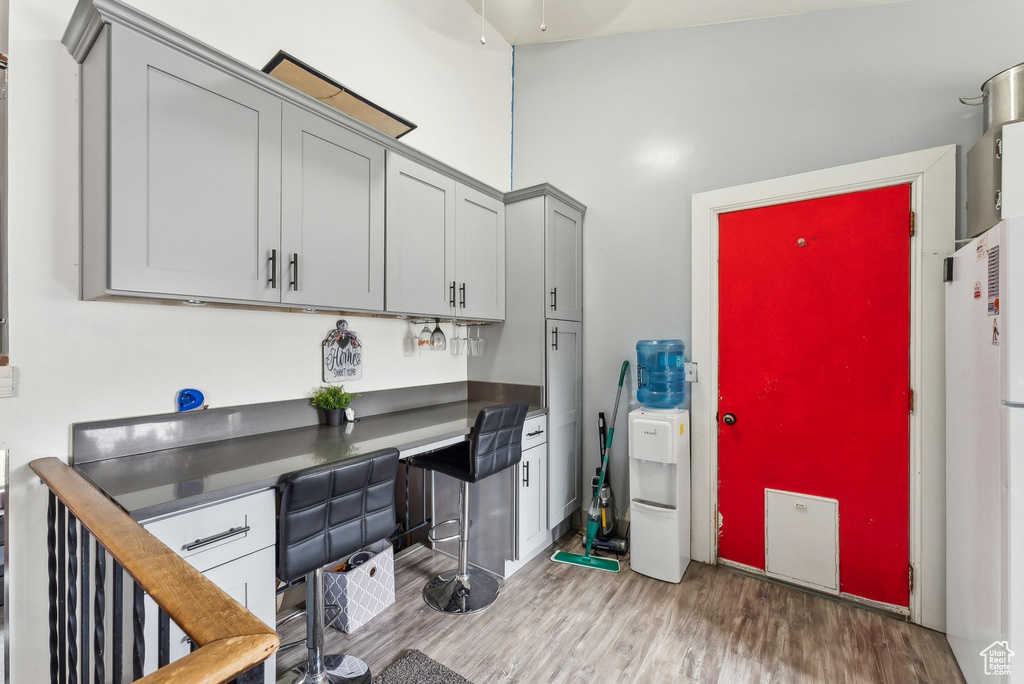 Kitchen featuring dark countertops, light wood finished floors, gray cabinets, and freestanding refrigerator