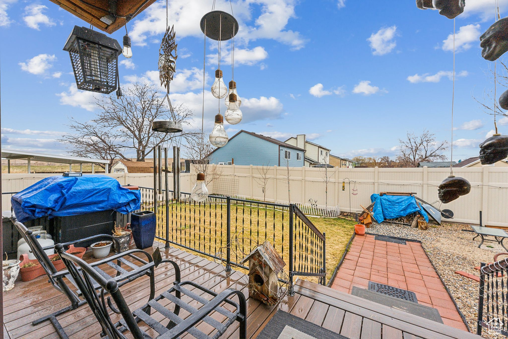 Wooden terrace featuring grilling area and a fenced backyard