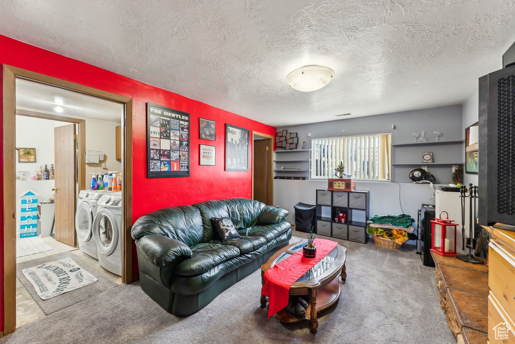 Living room with washer and dryer, carpet, and a textured ceiling