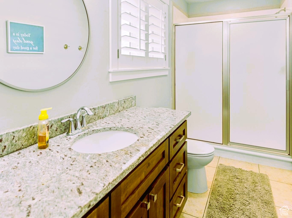 Full bathroom with vanity, visible vents, tile patterned floors, toilet, and a shower with door