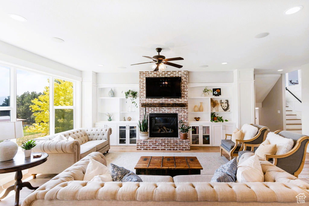 Living area featuring stairway, built in shelves, a fireplace, and light wood finished floors