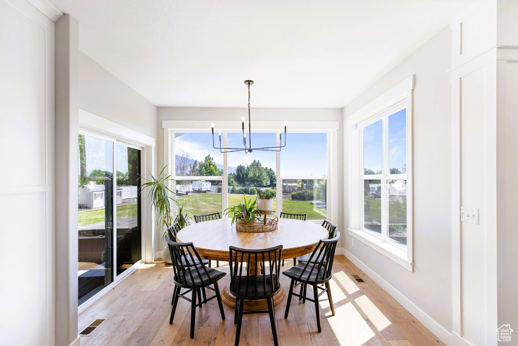Dining area with plenty of natural light, baseboards, light wood-type flooring, and visible vents