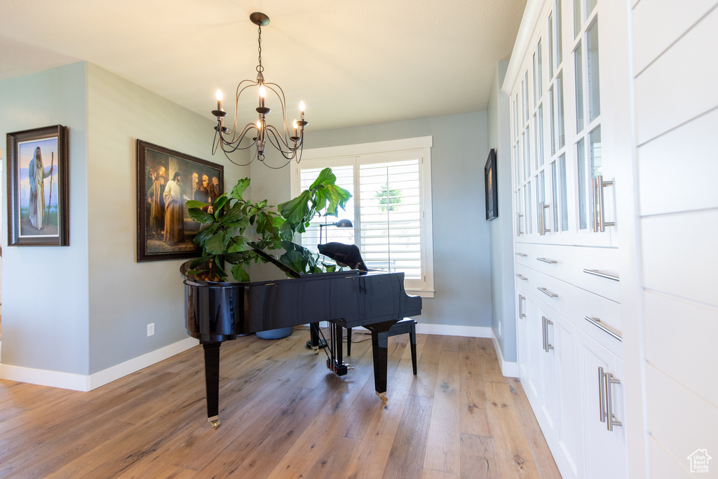 Sitting room featuring baseboards, a notable chandelier, and light wood finished floors