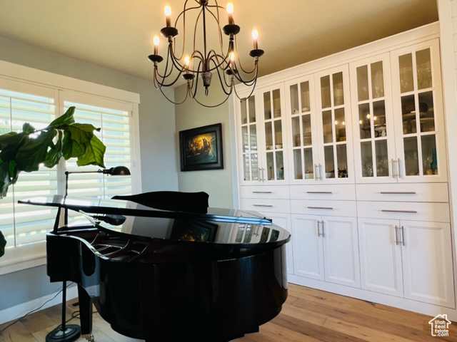 Office area featuring a notable chandelier and light wood-style floors