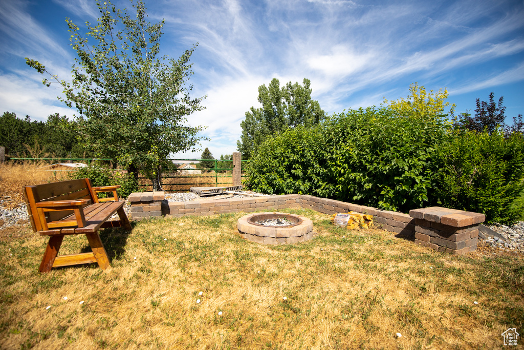 View of yard featuring an outdoor fire pit and fence
