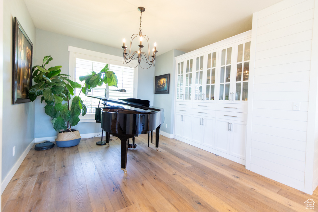 Sitting room featuring baseboards, a chandelier, and light wood finished floors