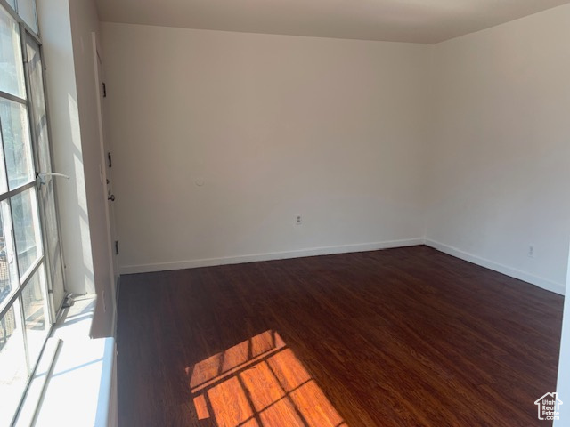 Unfurnished room with baseboards and wood finished floors