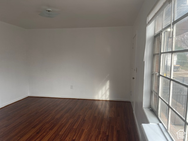 Empty room featuring baseboards and wood finished floors