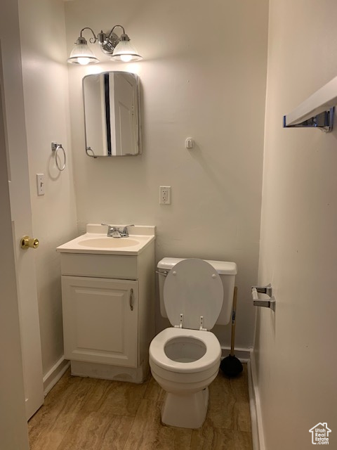 Bathroom with baseboards, toilet, and vanity