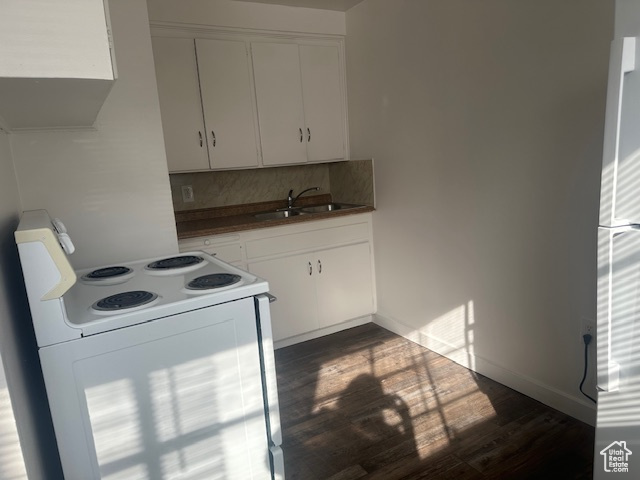 Kitchen featuring a sink, tasteful backsplash, dark wood finished floors, white cabinetry, and white range with electric stovetop