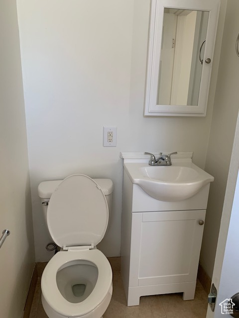Bathroom featuring vanity, toilet, and tile patterned flooring