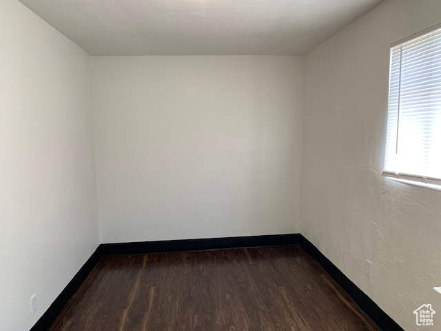 Spare room with baseboards and wood finished floors