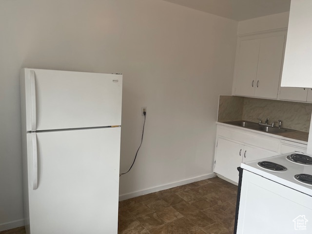 Kitchen with white cabinetry, white appliances, tasteful backsplash, and a sink