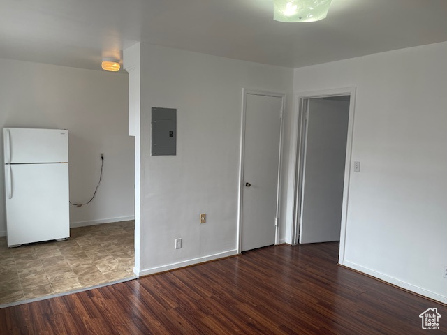 Interior space with electric panel, baseboards, and wood finished floors