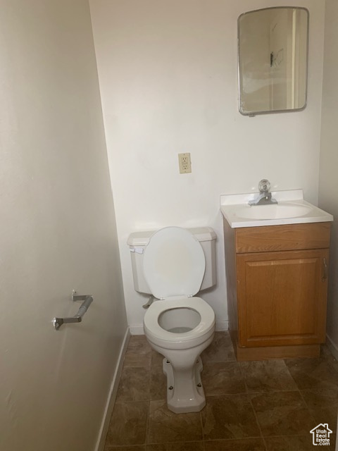 Half bath featuring vanity, toilet, and baseboards