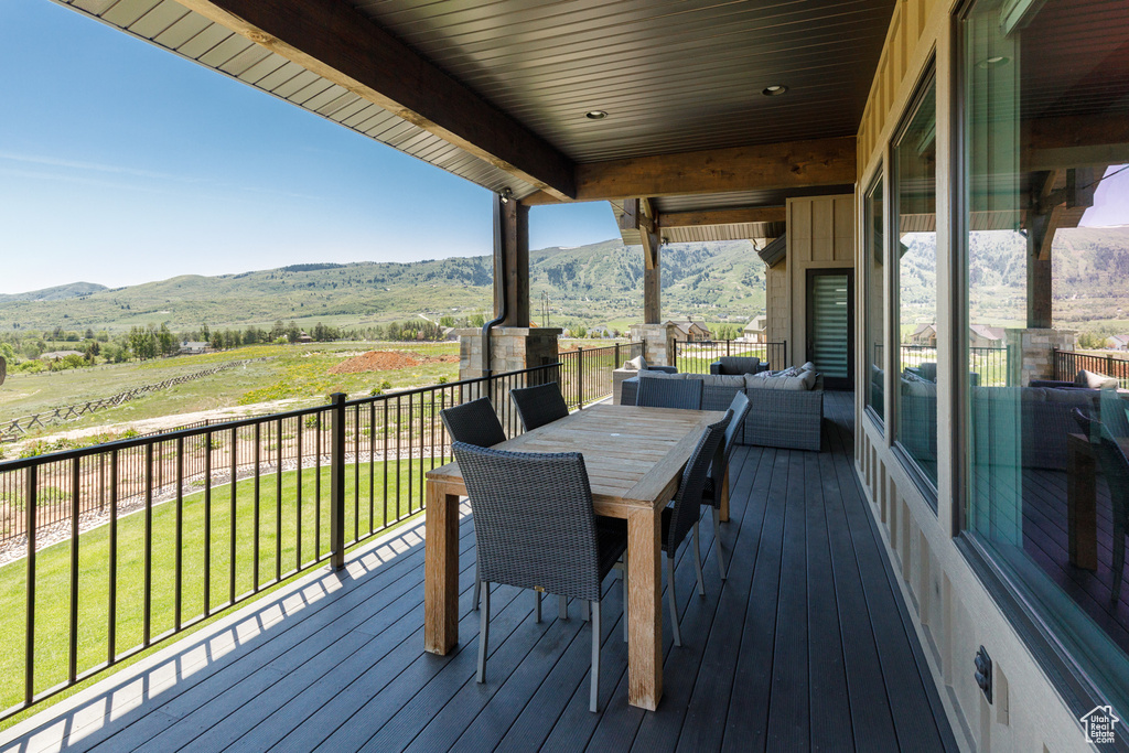 Wooden deck with a mountain view and a yard