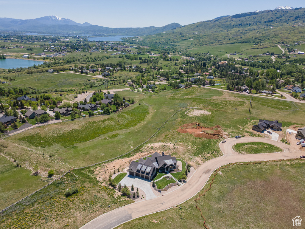 Aerial view of property and surrounding area featuring a water and mountain view