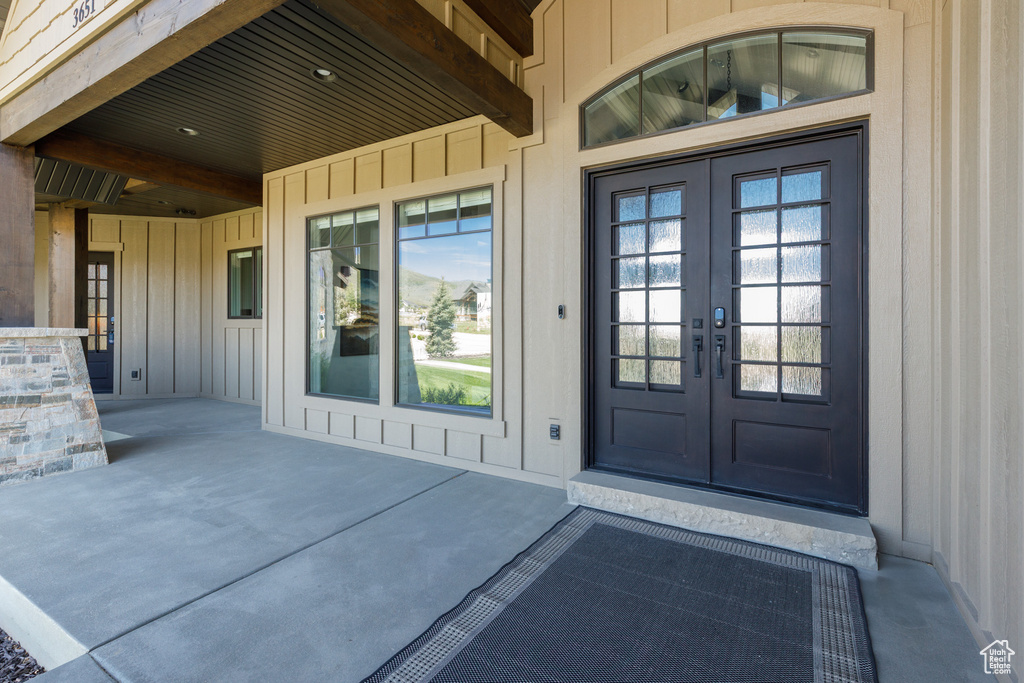 Entrance to property featuring french doors and board and batten siding