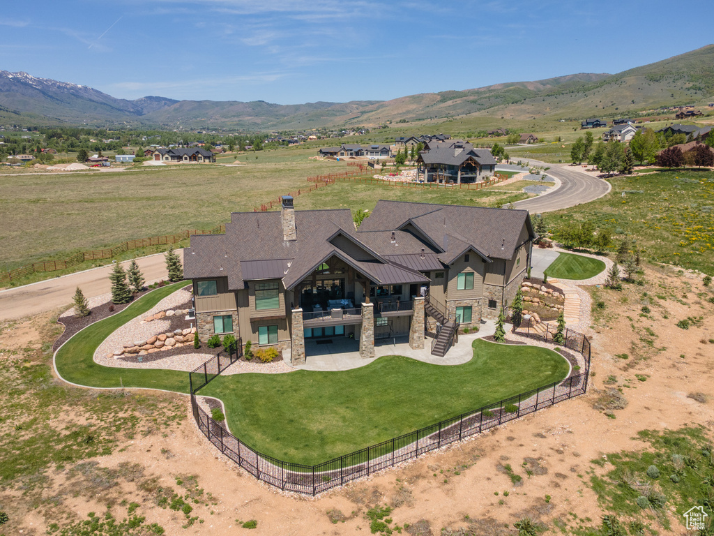 Aerial view of property and surrounding area with a mountain backdrop