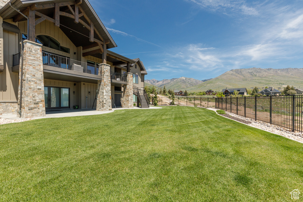 View of yard featuring a mountain view, a balcony, stairway, and a patio area