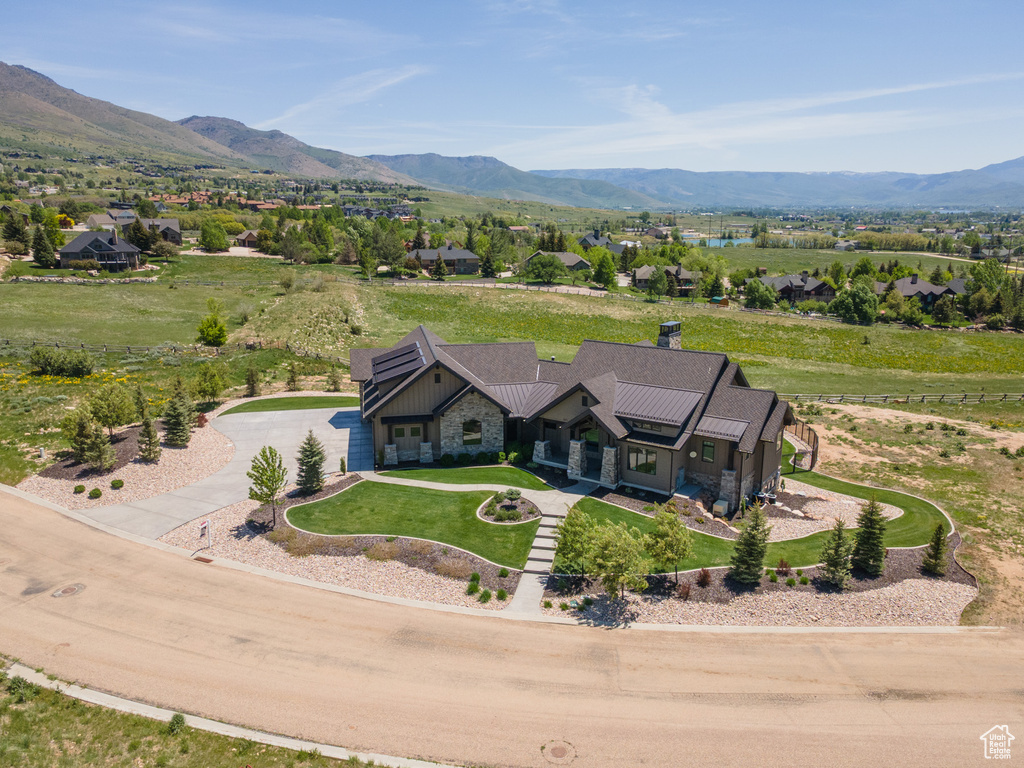 Aerial view of property and surrounding area with a mountainous background