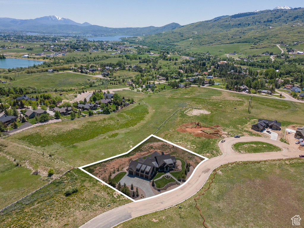 Aerial view of property and surrounding area with property parcel outlined and a water and mountain view