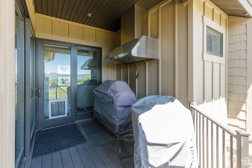 Doorway to property with board and batten siding and a deck