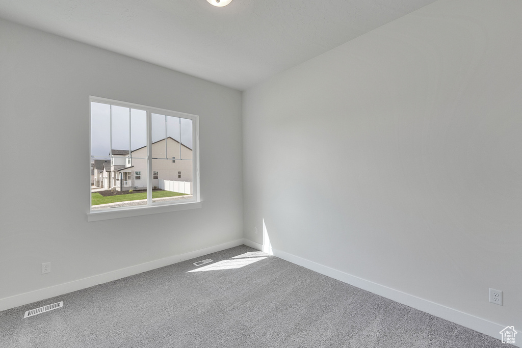 Spare room featuring baseboards and carpet flooring