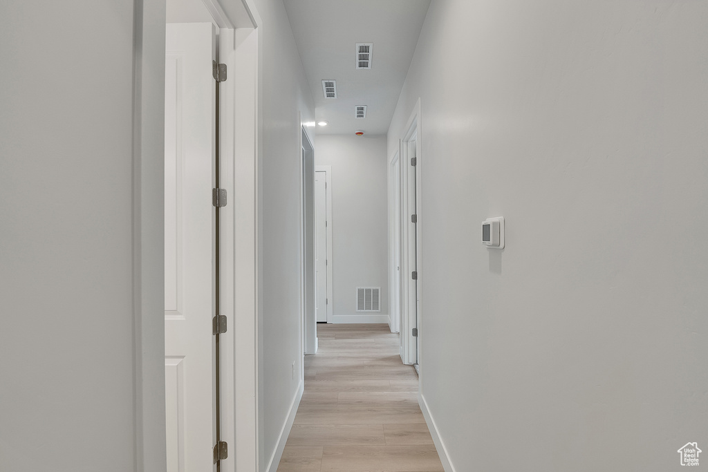 Hallway featuring light wood-style floors and baseboards