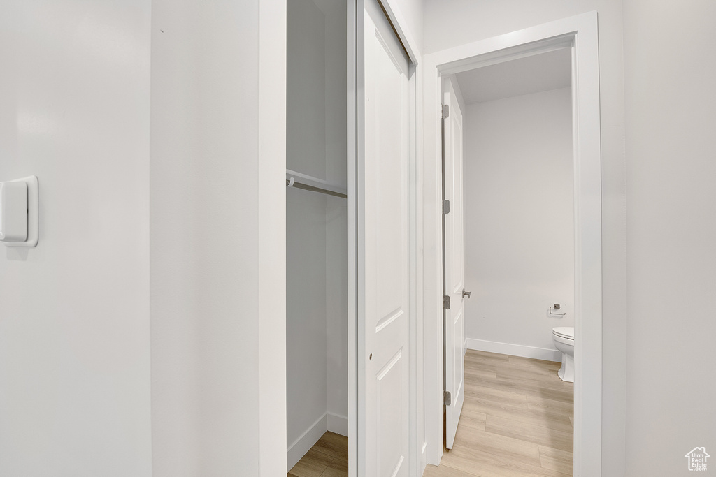 Bathroom featuring baseboards, wood finished floors, and toilet
