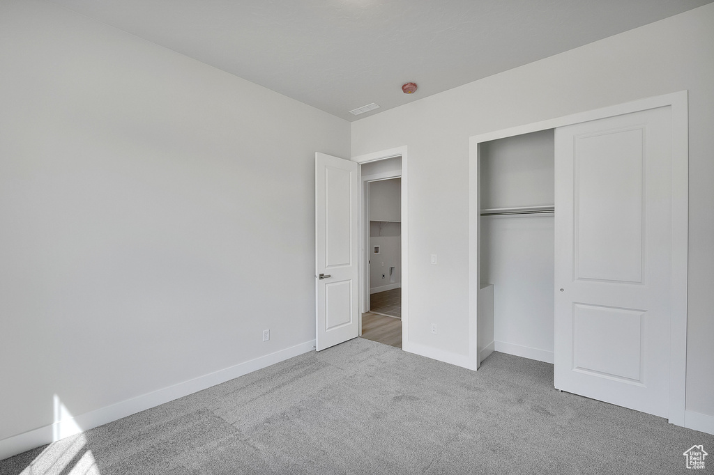 Unfurnished bedroom with carpet flooring, baseboards, and a closet