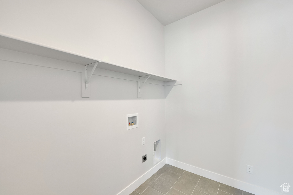 Washroom with washer hookup, baseboards, hookup for an electric dryer, and light tile patterned floors