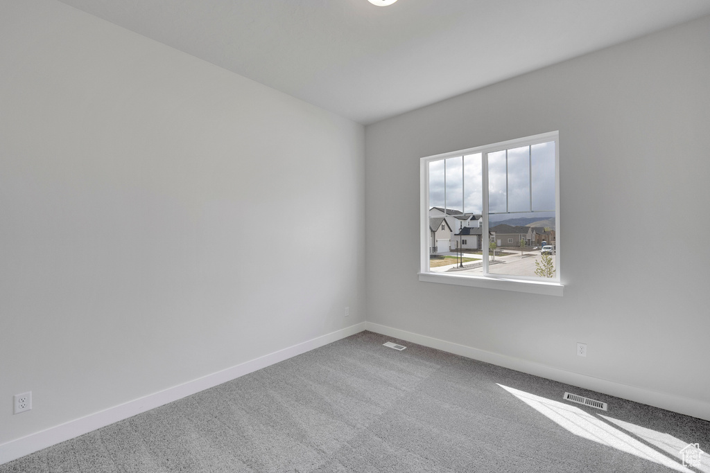 Spare room with carpet and baseboards