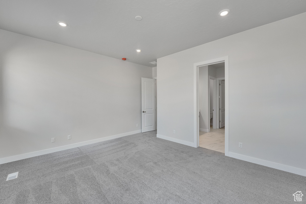 Carpeted empty room featuring recessed lighting and baseboards