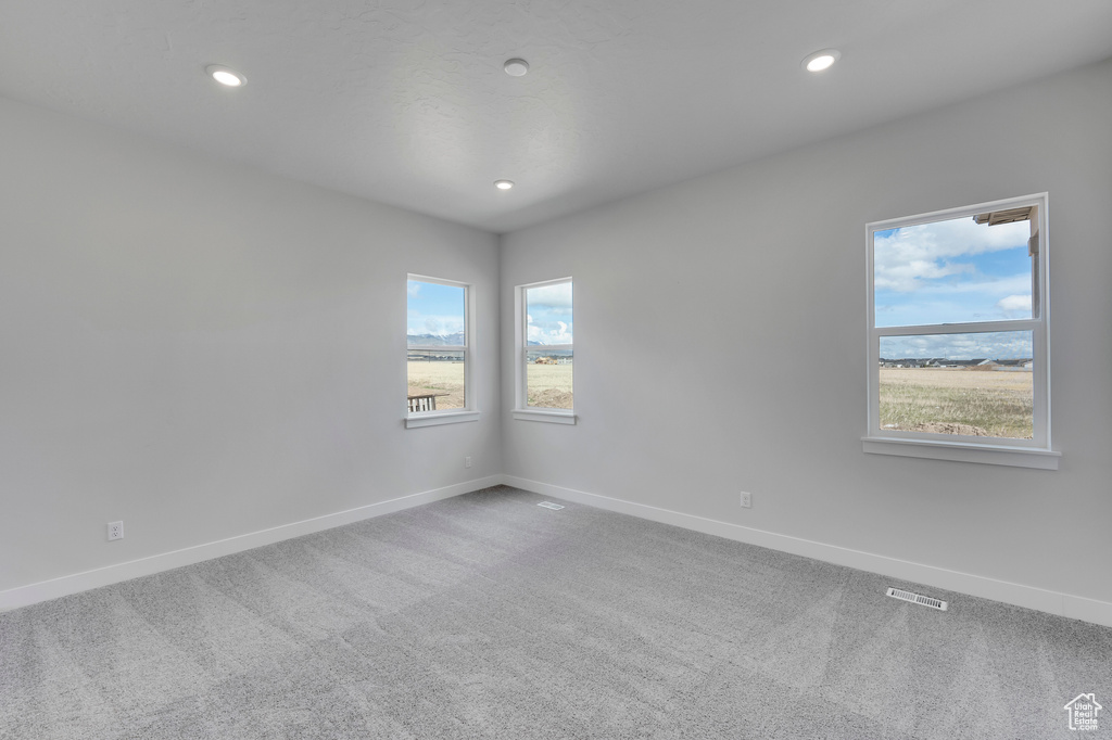 Carpeted spare room featuring baseboards and recessed lighting