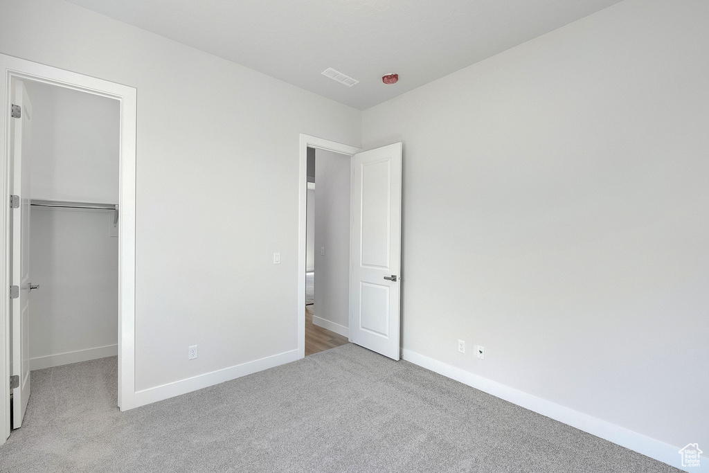 Unfurnished bedroom featuring carpet, baseboards, and a closet