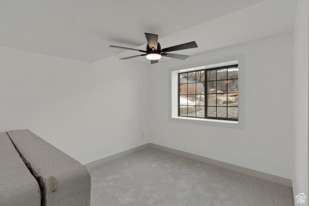 Unfurnished bedroom featuring carpet floors, a ceiling fan, and baseboards