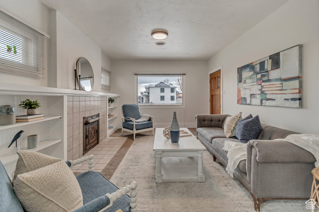 Living room featuring a tiled fireplace and baseboards