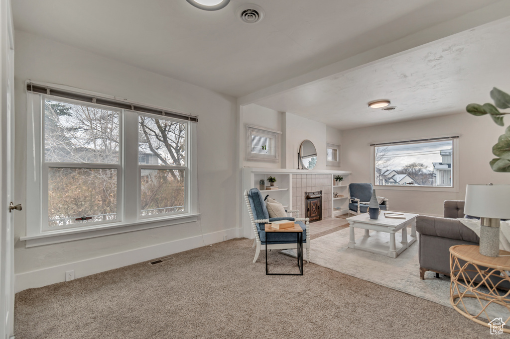 Living room with visible vents, a fireplace, baseboards, and carpet floors